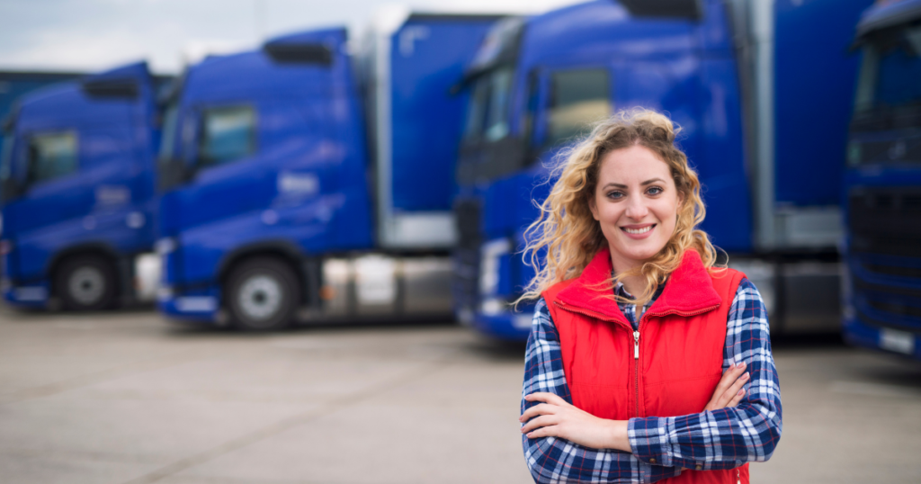 blond woman standing in front of blue trucks